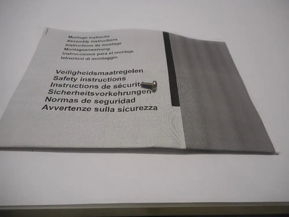 Montageanleitung mit Sicherheitshinweisen für ein Produkt der Marke Remeha, neben einer kleinen Schraube auf hellem Hintergrund.